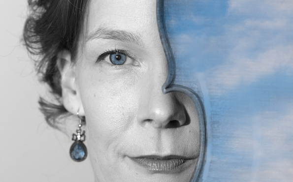 Lähikuvassa naisen kasvot, joista puolet on piilossa viulun takana.